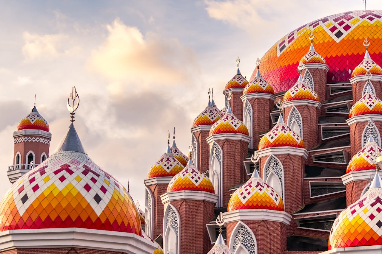 Intricate design of Masjid 99 Kubah in Makassar, Indonesia, at sunset showcasing vibrant colors.